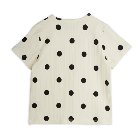 An off-white short-sleeve top with black polka dots, shown flat against a white background.