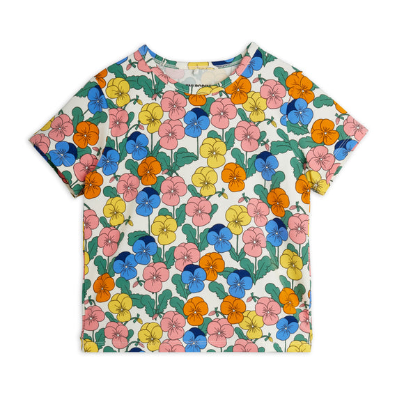 A short-sleeve crewneck t-shirt featuring a colorful floral print of pansies in pink, blue, yellow, and orange with green leaves on a white background.