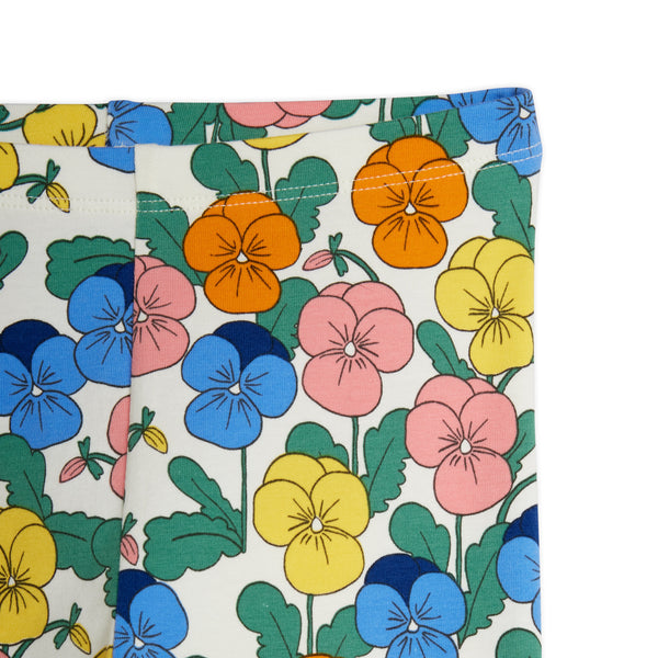 A close-up of a fabric product, likely a curtain panel or pocket panel, featuring a colorful print of pansies on a cream background. The print includes blue, pink, yellow, and orange flowers with green leaves.