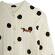 An off-white ribbed long-sleeve cardigan with black polka dots and a small embroidered brown dachshund on the chest, shown against a plain white background.