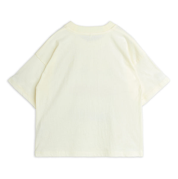 A pale cream-colored short-sleeve t-shirt shown from the back, laid flat against a solid white background.
