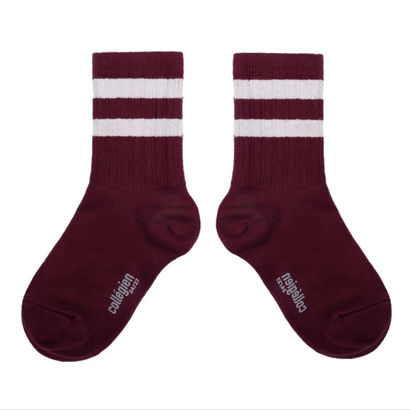 Pair of maroon socks with white stripes on a white background