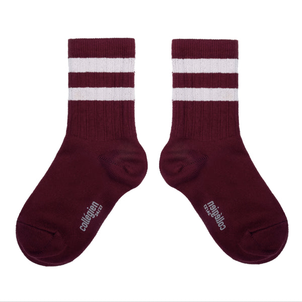 Pair of maroon socks with white stripes on a white background