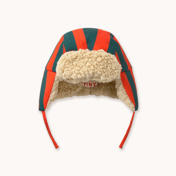 A chapka hat featuring the brand's signature red and green striped wool fabric, a beige sherpa fleece lining, and red ear loops, shown against a plain off-white background.