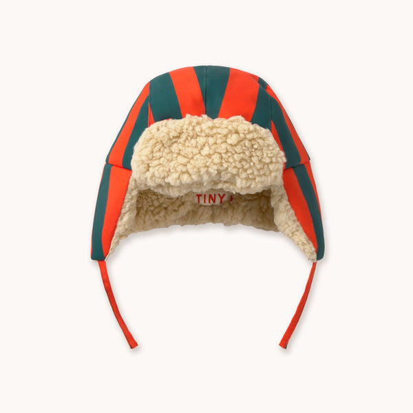 A chapka hat featuring the brand's signature red and green striped wool fabric, a beige sherpa fleece lining, and red ear loops, shown against a plain off-white background.