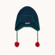 A dark navy blue ribbed knit beanie hat with a green trim around the ear flaps and two red pom-poms hanging from the ear ties, shown against a plain off-white background.