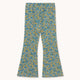 A pair of wide-leg pants featuring an all-over dense floral print in teal blue, yellow, and white, displayed flat against a light cream background.