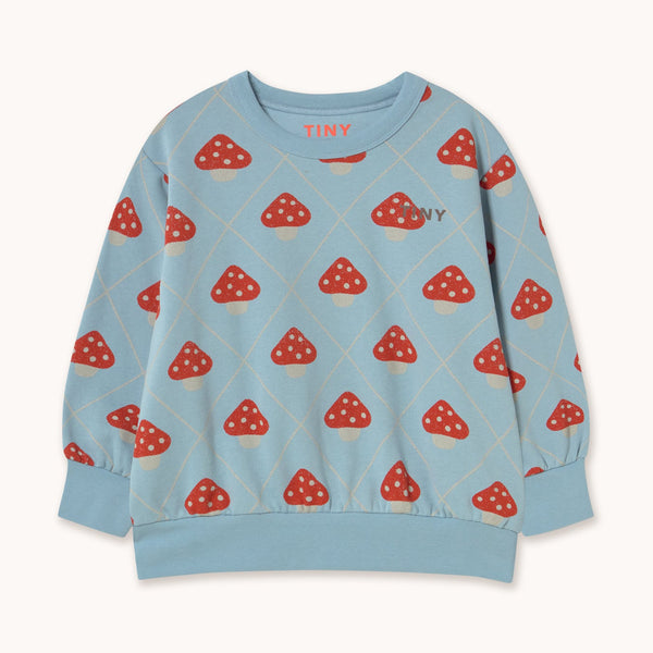 A light blue long-sleeve sweatshirt with a repeating red and white mushroom print, featuring the brand name 'TINY' on the chest and inside the collar, displayed on a clean off-white background.