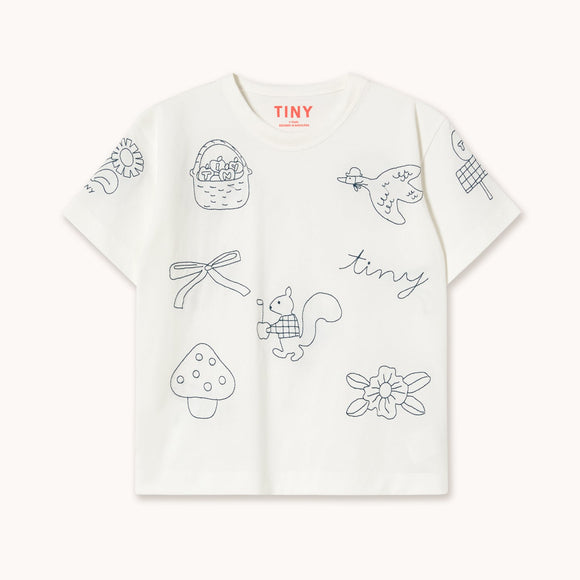 A white short-sleeve T-shirt with delicate black line-art illustrations of a basket, dragonfly, bird, mushroom, squirrel, flower, and the word 'tiny' across the front. The brand name 'TINY' is printed in red on the inside neck label.