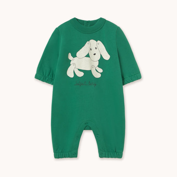 A green short-sleeve baby romper with a white cartoon dog graphic on the chest, displayed flat against a light off-white background.