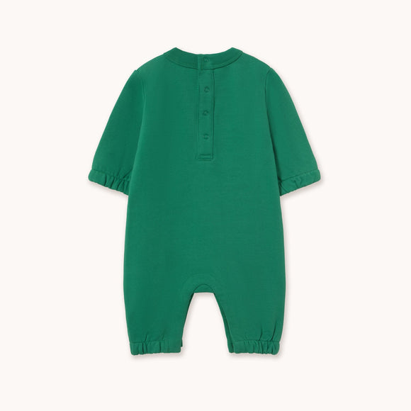 A green short-sleeve baby romper with a buttoned henley neckline, photographed flat against a light cream background.