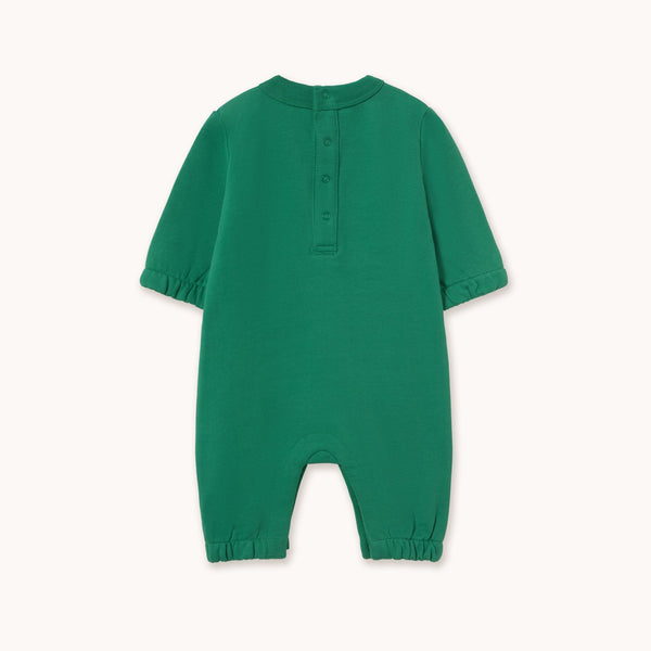 A green short-sleeve baby romper with a buttoned henley neckline, photographed flat against a light cream background.