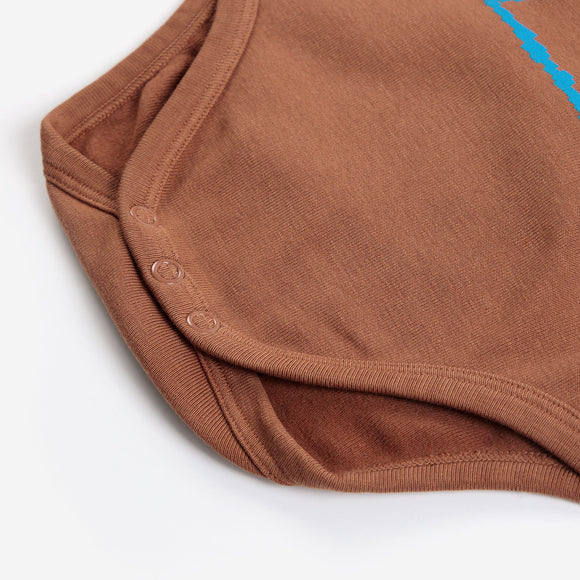 Close-up of a brown ribbed knit garment, likely a bodysuit or romper, showing the sleeveless neckline, snap-button closure, and a small bright blue graphic accent on a white background.