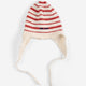 A cream-colored knit baby beanie hat with red horizontal stripes and matching tie straps, shown against a plain white background.