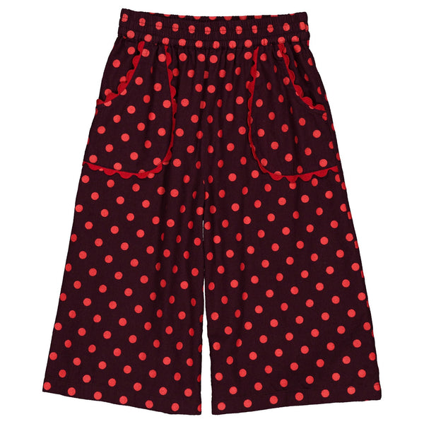 Red and black polka dot wide-leg shorts with an elastic waistband and side pockets, shown flat on a white background.