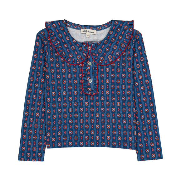 A long-sleeve top for kids by Hello Simone, featuring a blue base with a red and white geometric pattern, a ruffled collar, and a ruffled placket with red piping.