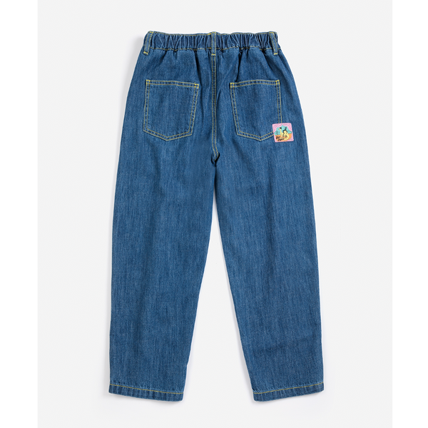 Blue denim jeans shown from the back, featuring an elastic waistband, two back pockets, and a small colorful patch on the right pocket, photographed against a light gray background.