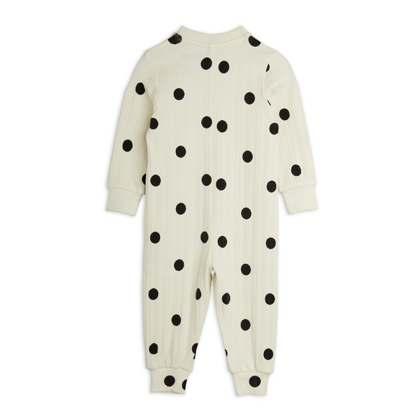 A cream-colored ribbed baby jumpsuit with black polka dots, shown from the back on a plain white background.