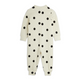 A cream-colored ribbed baby jumpsuit with black polka dots, shown from the back on a plain white background.