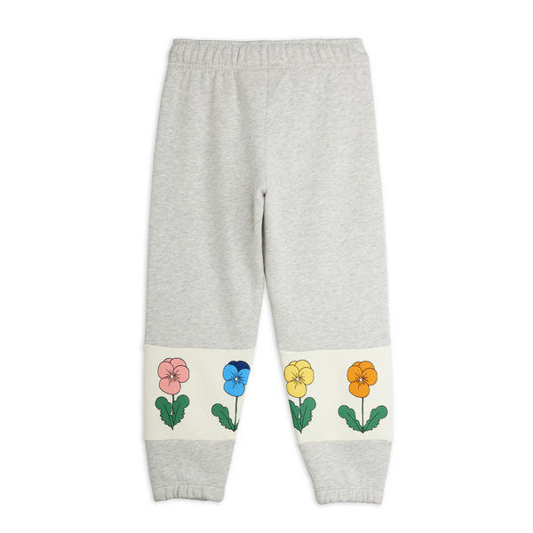 Light heather gray sweatpants with a cream-colored band near the ankles featuring embroidered pansy flowers in pink, blue, yellow, and orange.
