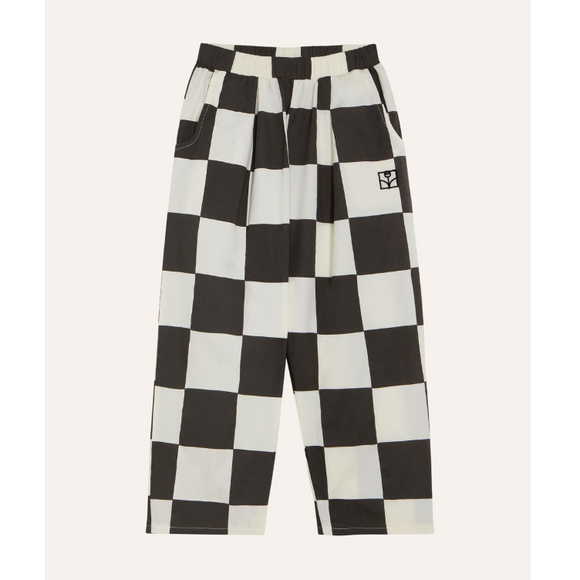 Black and off-white checkered cropped pants with an elastic waistband and side pockets, shown flat against a light beige background.