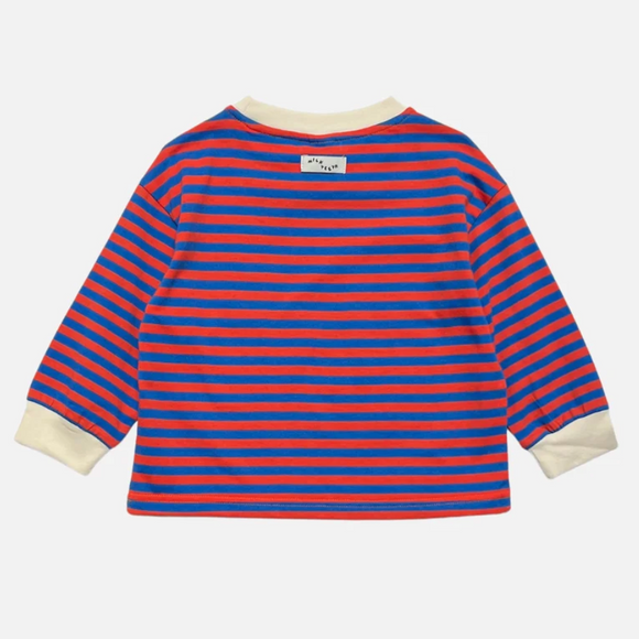 A long-sleeve striped shirt shown from the back, featuring horizontal red and blue stripes with cream-colored ribbed collar and cuffs. A small white brand label is visible at the back neck.