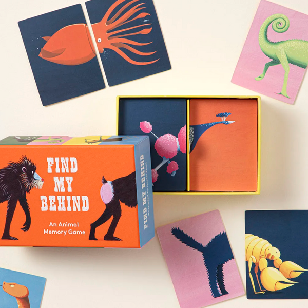 Animal memory game set with a colorful box and illustrated cards on a light cream background. The box reads 'FIND MY BEHIND' and shows animal silhouettes, with several matching cards scattered around it.