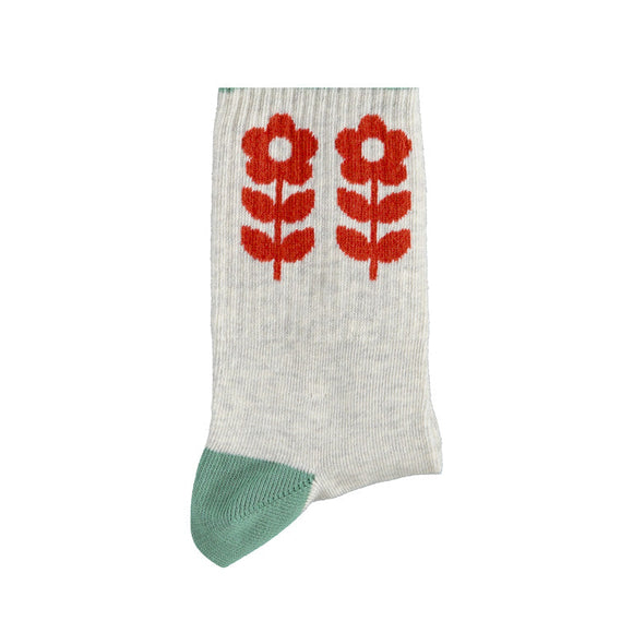 White sock with red floral design and green toe on a white background